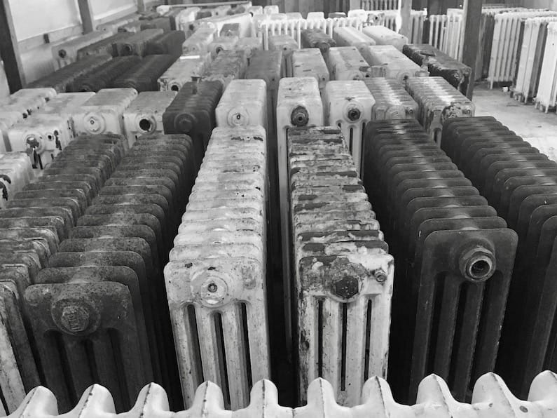 Large number of old victorian school radiators in a warehouse