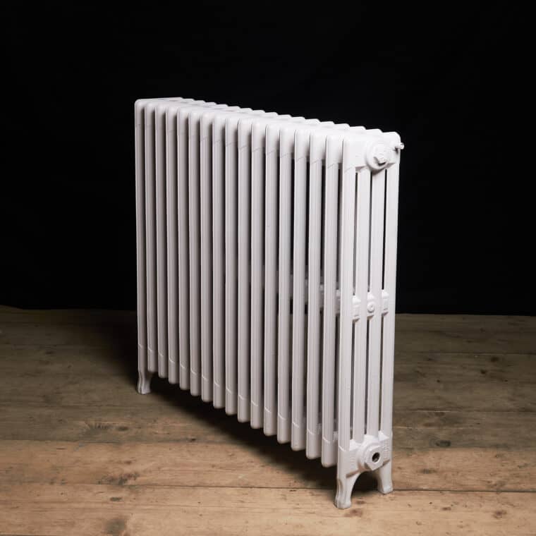 Traditional columned cast iron radiator painted pale pink