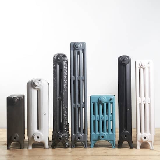 group of various old fashioned cast iron radiators painted different colours